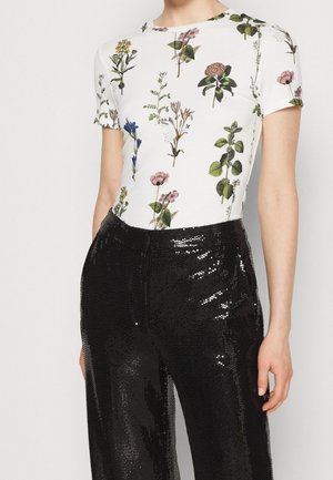 Hvid kortærmet top med farverige blomsterprints, kombineret med skinnende sorte palietter med vide ben. Glat stof med let stretch.