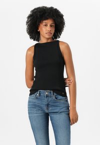 Zwarte geribbelde tanktop met een ronde hals en een aansluitende pasvorm, gecombineerd met medium-wash blauwe jeans met een klassieke vijf-pocketontwerp.