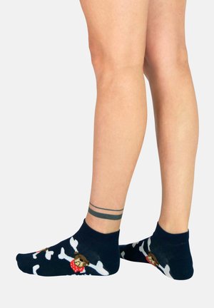 Calcetines navy con patrón de huesos blancos y un oso que lleva una bandana roja. De longitud corta hasta el tobillo, textura de punto y puño elástico.
