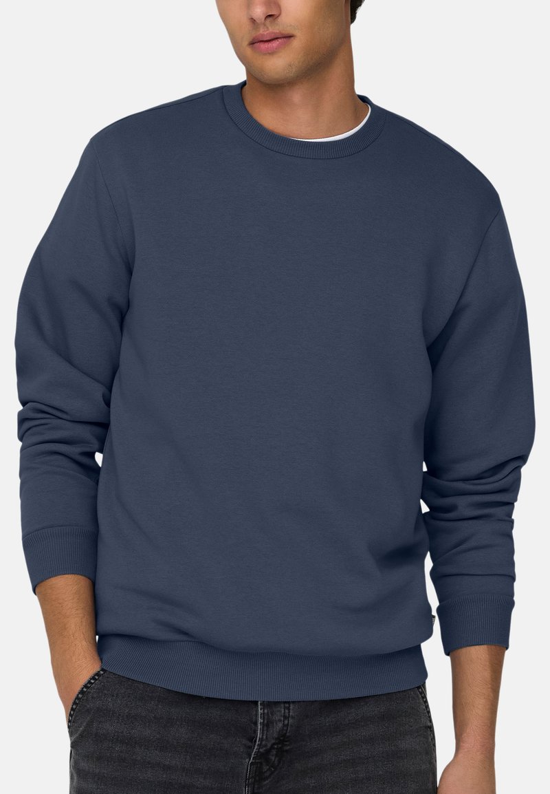 Sweatshirt bleu marine en mélange de coton, avec un col rond, des poignets côtelés et une coupe décontractée. Design minimaliste, sans motifs ni logos visibles.