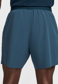 Men's athletic shorts in a dark teal color. Soft, lightweight fabric with an elastic waistband. Straight cut with minimal stitching details.