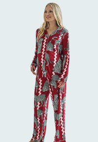 Punainen satiininen pyjama-setti, jossa on leopardikuvio ja sahalaitakuosi. Pitkähihaista nappipaitaa, jossa on rintatasku, sekä siihen sopivat housut.