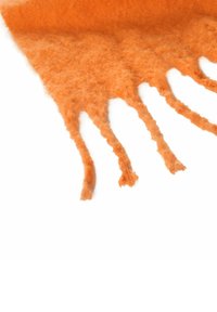 Écharpe douce en laine orange avec des extrémités à franges, posée à plat sur un fond blanc.