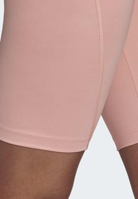 Rosa högmidjade shorts gjorda av slätt elastiskt material, med platta sömmar och en slimmad design.