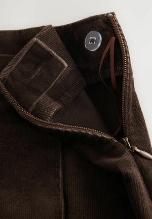Brown corduroy fabric with a smooth texture, featuring a zipper, button closure, and an interior tab for secure fastening.