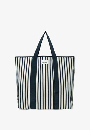 Le sac fourre-tout rayé présente des rayures verticales bleu marine et crème, un tissu résistant, deux anses en tissu et une étiquette blanche avec le logo "DAY ET".