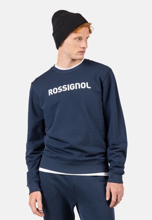 Sudadera azul marino con el texto blanco "ROSSIGNOL", fabricada en una tela suave. Presenta un cuello redondo clásico y puños y dobladillo acanalados.