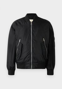 Veste bombers noire en nylon lisse. Dotée d'une fermeture éclair sur le devant, de deux poches latérales inclinées et de poignets et ourlet côtelés. Design simple.