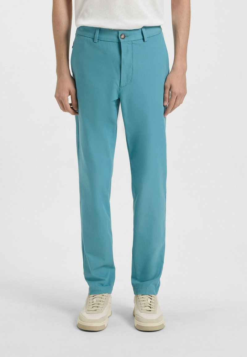 Turkusowe spodnie o dopasowanym kroju z zapięciem na guzik. Wykonane z lekkiego materiału, charakteryzujące się gładkim przodem, bocznymi kieszeniami i gładką teksturą.