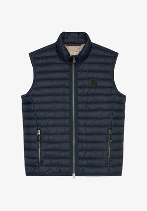 Merinovärinen tikkiliivi korkealla kauluksella, edessä vetoketjusuljenta ja kaksi sivuilla vetoketjullista taskua. Sisältää pienen logopatchin rinnassa.