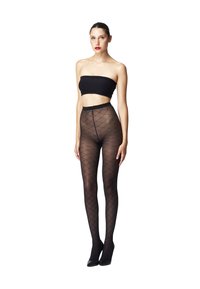 Collant neri a fantasia realizzati in materiale trasparente con un design a rombi, abbinati a un top bandeau nero e tacchi neri.