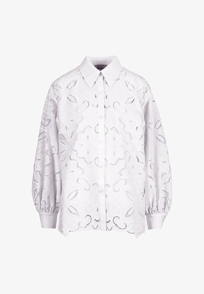 Weiße Bluse mit Knopfleiste, aufwendigen floralen Ausschnittmustern, langen, gepufften Ärmeln und spitzem Kragen.