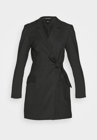 Blazer noir sur mesure à manches longues, avec un design croisé, des poches avant et une ceinture nouée à la taille. Confectionné dans un tissu lisse.