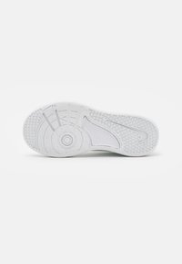 Suola bianca di scarpa da ginnastica con gomma testurizzata per una presa migliore, con motivi circolari e logo Nike. Finitura liscia con leggera maculatura in tutto.