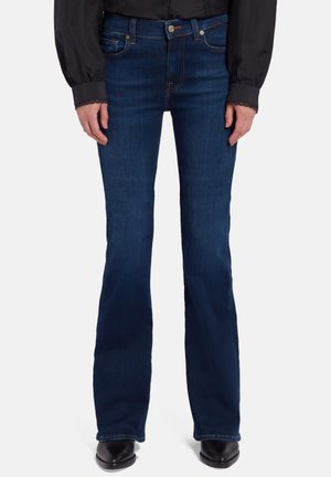 Temno modri zvonasti teksasi z gladko denim teksturo, zasnovo s petimi žepi in kovinskim gumbom za zapiranje v pasu. Klasičen slog.