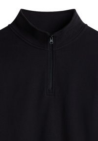 Sudadera de forro polar negra con cremallera y un cuello alto. Presenta una cremallera frontal y una tela suave y texturizada. Diseño minimalista, sin patrones.