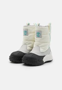 Pohodlné zimní boty v bílé a šedé barvě s polstrováním, s texturovanými černými gumovými podrážkami, zdobené akcenty v barvě teal a měkkým zateplením pro teplo.