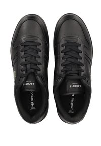 Paire de baskets en cuir noir Lacoste avec lacets noirs, logo de la marque visible sur les languettes et le côté, vue de dessus.