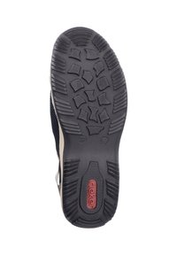 Black rubber outsole with textured tread pattern; designed for grip and stability. Upper features navy textile and beige accents.