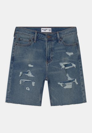 Denimshorts i mellemblå med slidte detaljer. Har flossede revner og lige kant. Klassisk design med fem lommer og knaplukning.
