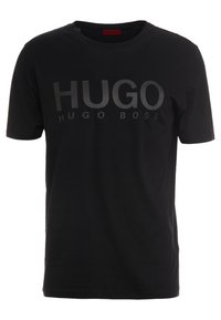 Černé bavlněné tričko s krátkým rukávem, s výrazným matným černým nápisem "HUGO" a menším logem "HUGO BOSS" pod ním. Jednoduchý kulatý výstřih.