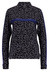 Jersey de manga larga en patrón de leopardo en blanco y negro, con una franja horizontal azul marino y un cuello alzado con un detalle en forma de anillo.
