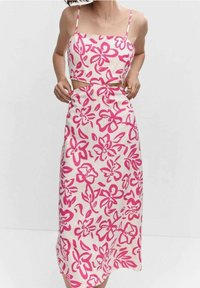 Dwuczęściowy strój składający się z krótkiego topu i długiej spódnicy. Wykonany z lekkiego materiału w kwiatowy wzór w odcieniach różu i kremu.