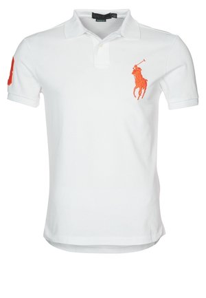 Polo blanc à manches courtes avec un logo de joueur de polo orange sur le côté gauche de la poitrine et un écusson orange sur la manche droite.