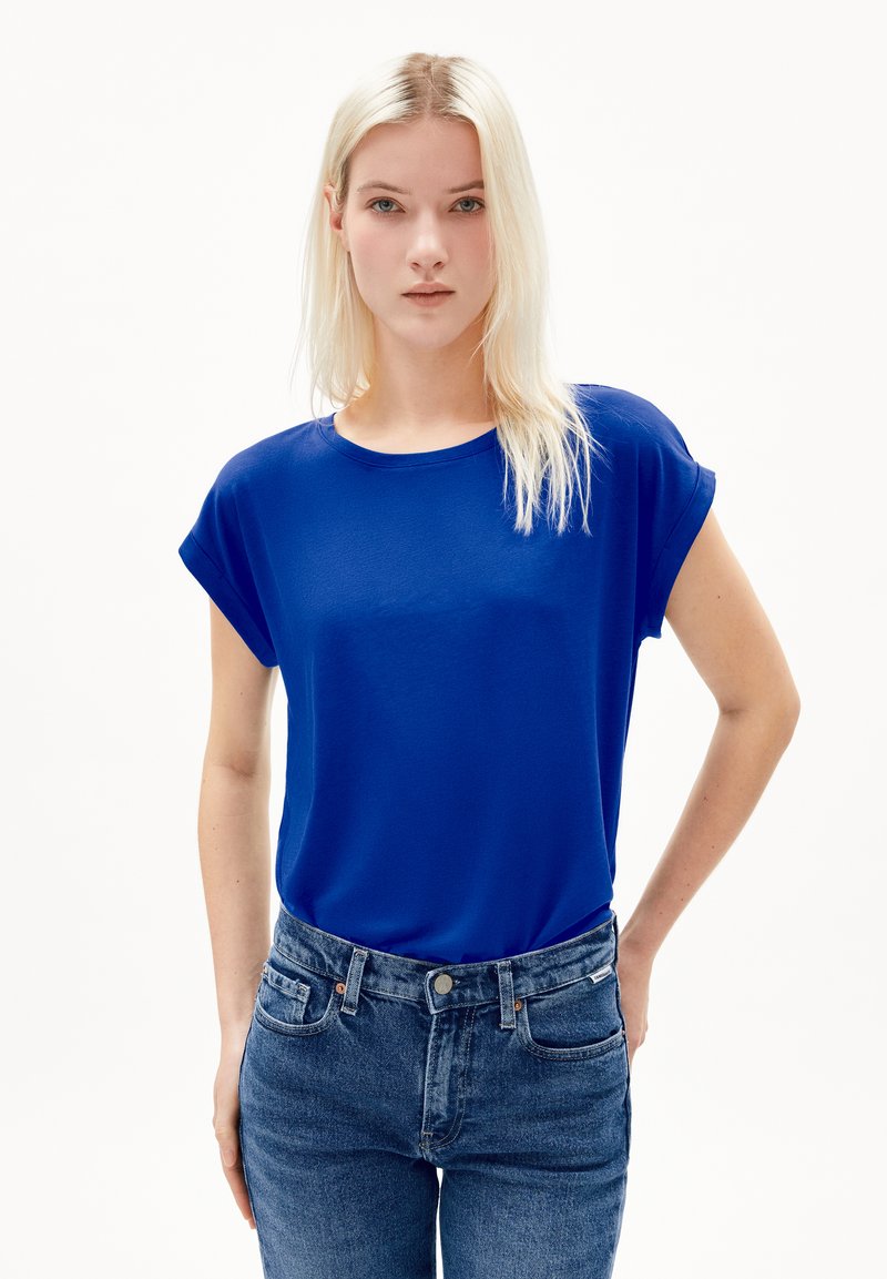 Blauwe korte mouwen top van een soepele stof, ronde halslijn en een relaxed fit, gecombineerd met high-waisted vervaagde blauwe jeans.