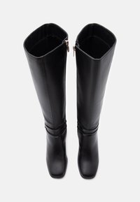 Μαύρες μπότες μέχρι το γόνατο από λείο δέρμα με τετραγωνισμένο δάχτυλο, διαθέτοντας δύο πλαϊνές φερμουάρ και μια διακοσμητική ζώνη γύρω από τον αστράγαλο.
