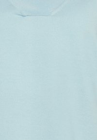 Jasnoniebieski sweter dzianinowy o gładkiej fakturze i szerokim dekolcie. Posiada prążkowane wzory wzdłuż brzegów i korpusu.