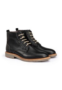Bottines en cuir noir avec des lacets beiges, bout rond, finition texturée et semelles en caoutchouc avec un léger accent beige le long du bord.