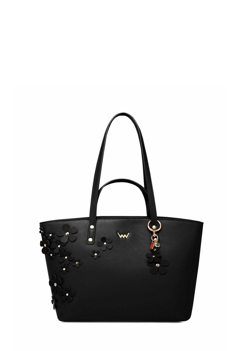 Černá syntetická taška typu tote s květinovou aplikací, zlatým kováním a ozdobným přívěskem. Má dvě pevné rukojeti a strukturovaný tvar.