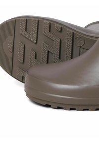 Bottes en caoutchouc imperméables, marron, avec une finition lisse, des semelles épaisses et un bout arrondi. Des motifs de traction sur la semelle offrent une adhérence.