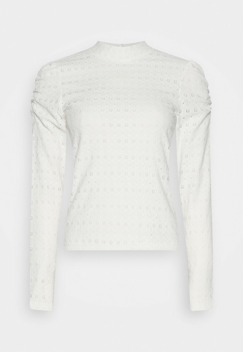 Maglietta bianca a maniche lunghe in tessuto strutturato con motivi circolari. Design aderente con spalle arricciate e colletto alto.