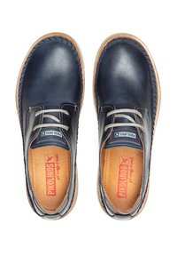 Chaussures en cuir marine avec une texture lisse, bout rond, accents gris contrastants et semelle beige. Présentent un design à lacets et une semelle intérieure de marque.