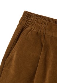 Pantaloni in velluto a coste marroni con cintura elastica, caratterizzati da un tessuto testurizzato, tasche laterali e cuciture visibili lungo le stecche.