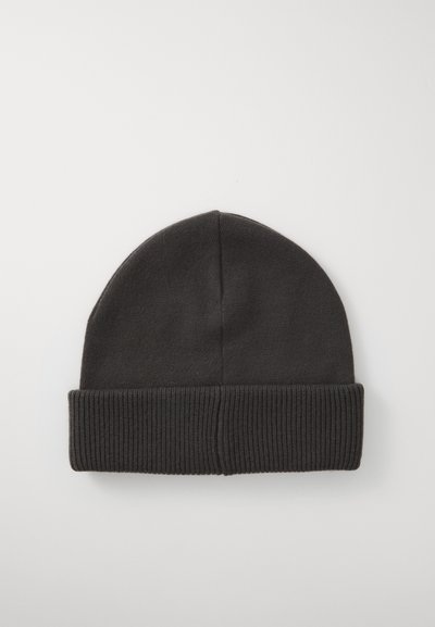Svart stickad mössa med ribbat kant. Materialet är mjukt och flexibelt, med en slät yta och en rundad toppdesign.