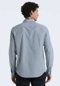 Gestreepte lange mouwen shirt in blauw en wit, met een klassieke kraag, knoopmanchetten en een gebogen zoom. Zachte stoftextuur.