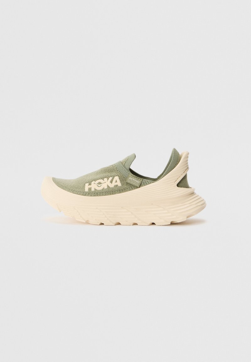 Hoka slip-on sneaker in olive green with a textured upper, cream-colored sole, and distinctive ridged design for enhanced support.