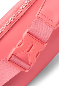 Borsa a spalla rosa con esterno testurizzato, zip liscia e una robusta fibbia in plastica con tracolla in nylon rosa per una chiusura sicura.