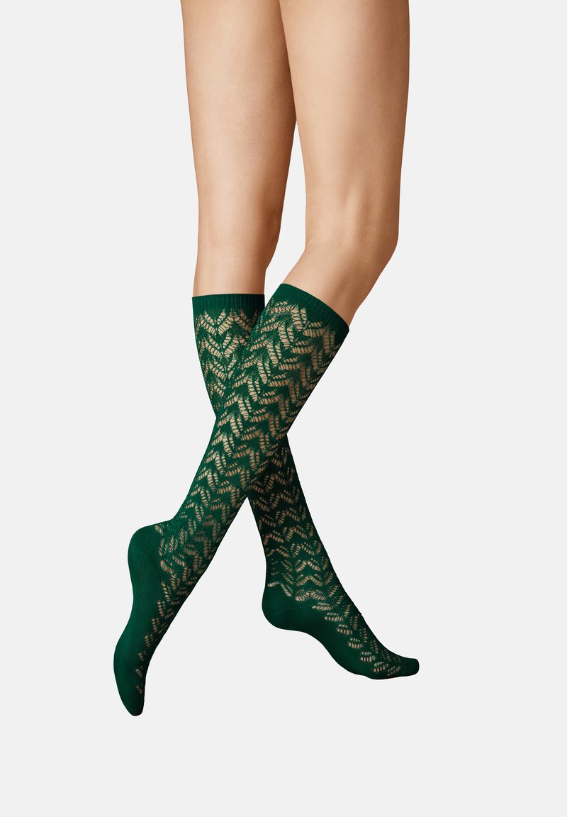 Grüne kniehohe Socken mit einem geometrischen Spitzenmuster, geripptem oberen Rand und einer glatten Textur, die entwickelt wurden, um die Sichtbarkeit der Beine zu erhöhen.