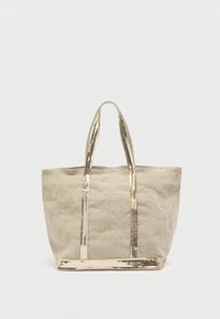 Sac fourre-tout en toile beige avec des anses et une base en métal doré, présentant un design simple et non structuré ainsi qu'une surface légèrement texturée.