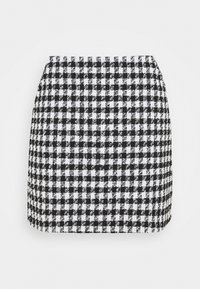 Mustak-white ruuduline mini seelik struktureeritud disainiga, millel on sile tekstuur ja vormitud siluett. Nähtavat riistvara pole.