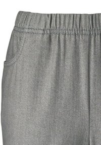 Grijze, elastische taillebandbroeken van een textuurstof, met zijzakken en een gladde afwerking. Close-up van het taillegebied.