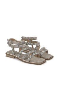 Beige sandalen met gestructureerde bandjes en strasstenen accenten. Vierkante neusontwerp, platte hak en meerdere verstelbare bandjes voor comfort.