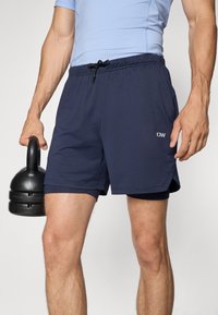 Marineblaue Sportshorts mit Netzstruktur, elastischem Bund und Kordelzug. Mit kleinem weißem Logo an der Seite.