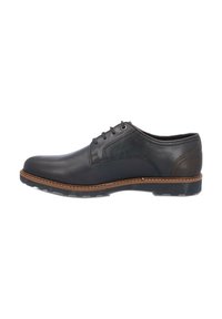 Zapato de vestir de cuero negro con textura suave, puntera redondeada, detalles de costura, acentos marrones en la suela y cierre de cordones.