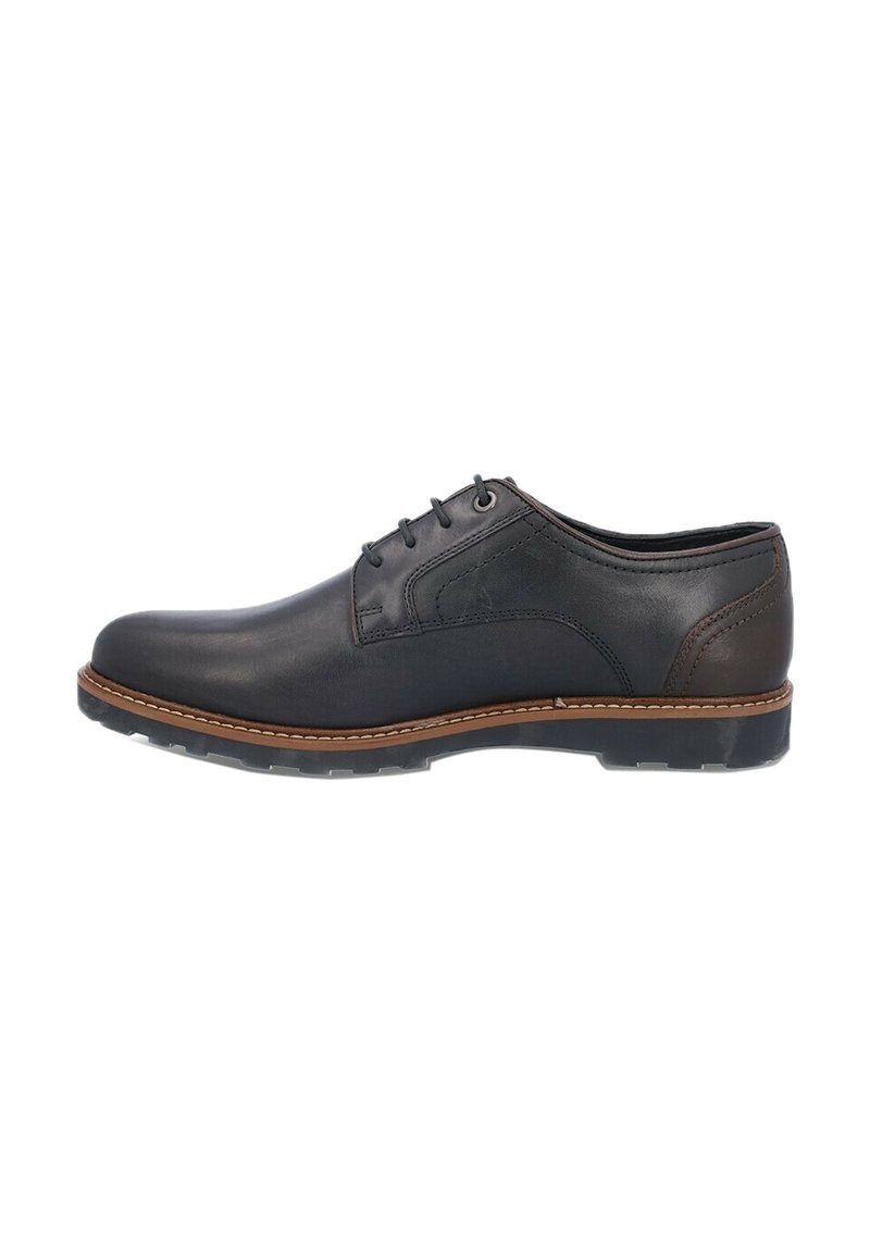 Zapato de vestir de cuero negro con textura suave, puntera redondeada, detalles de costura, acentos marrones en la suela y cierre de cordones.
