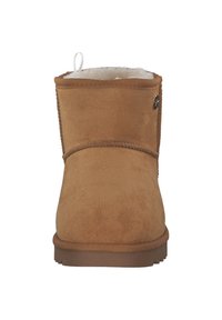 Brauner Wildleder-Stiefelette mit weichem weißem Innenfutter, Schlaufe an der Rückseite und flacher Gummisohle. Verziert mit dekorativen Nähten.